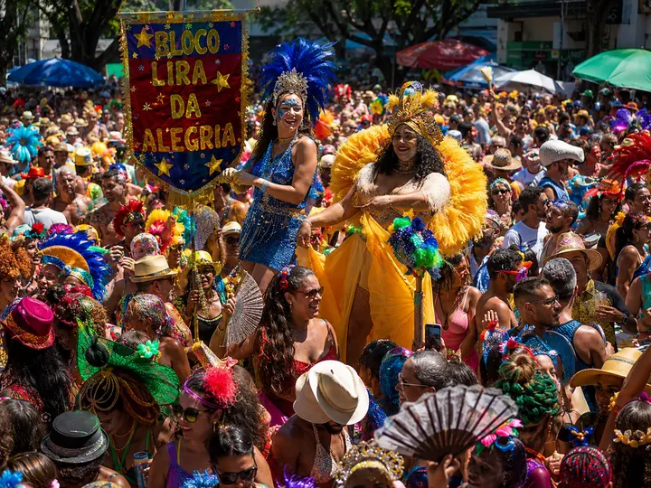 A bloco street party moving through Rio behind its banner
