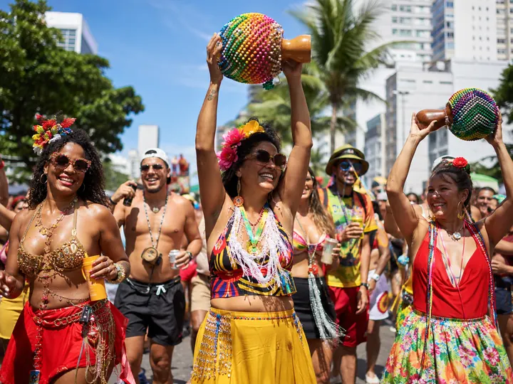 Dancers shaking beaded shakers at a street party near Copacabana